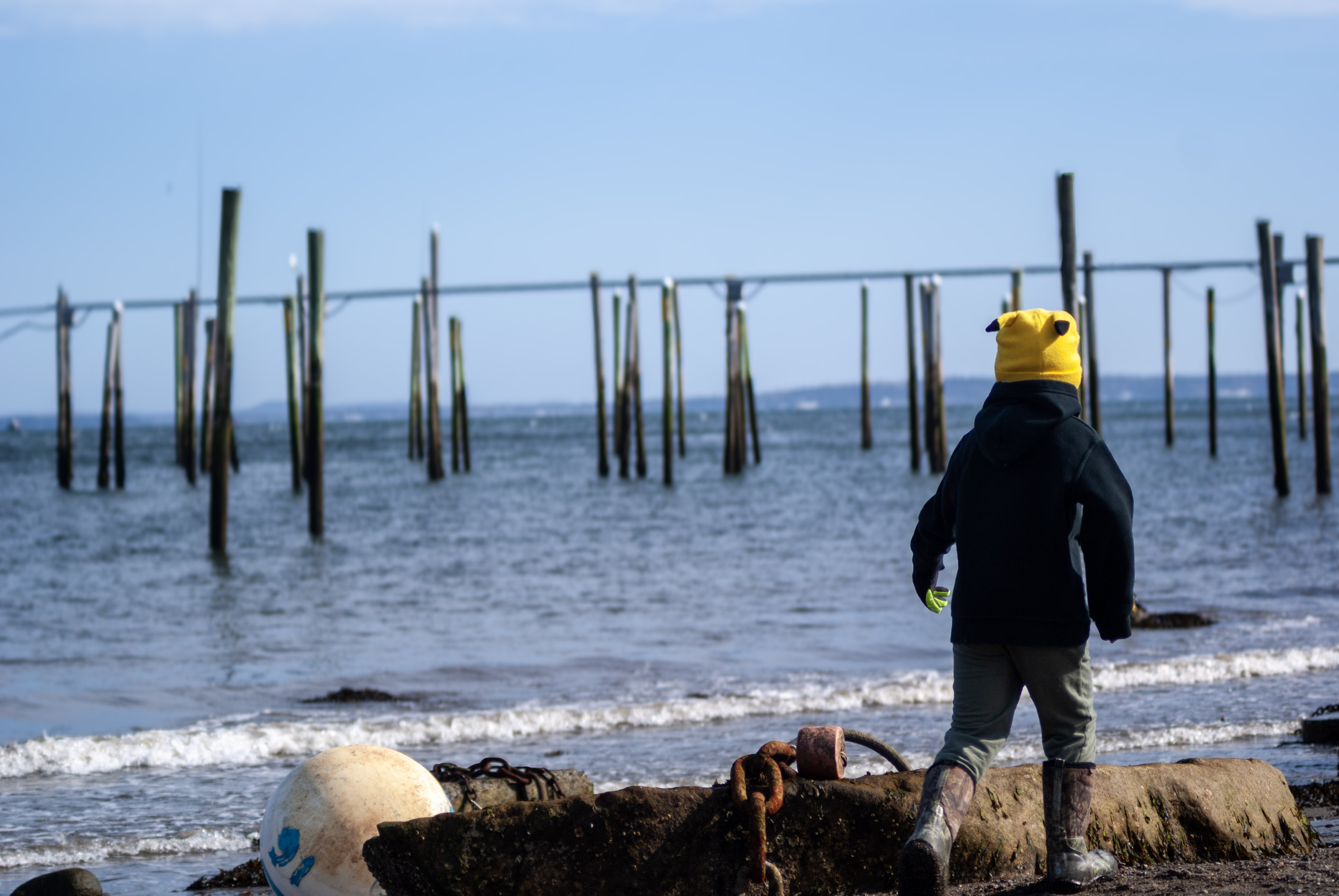 Bride smiling back from a canoe on a quiet Maine lake at sunset.
